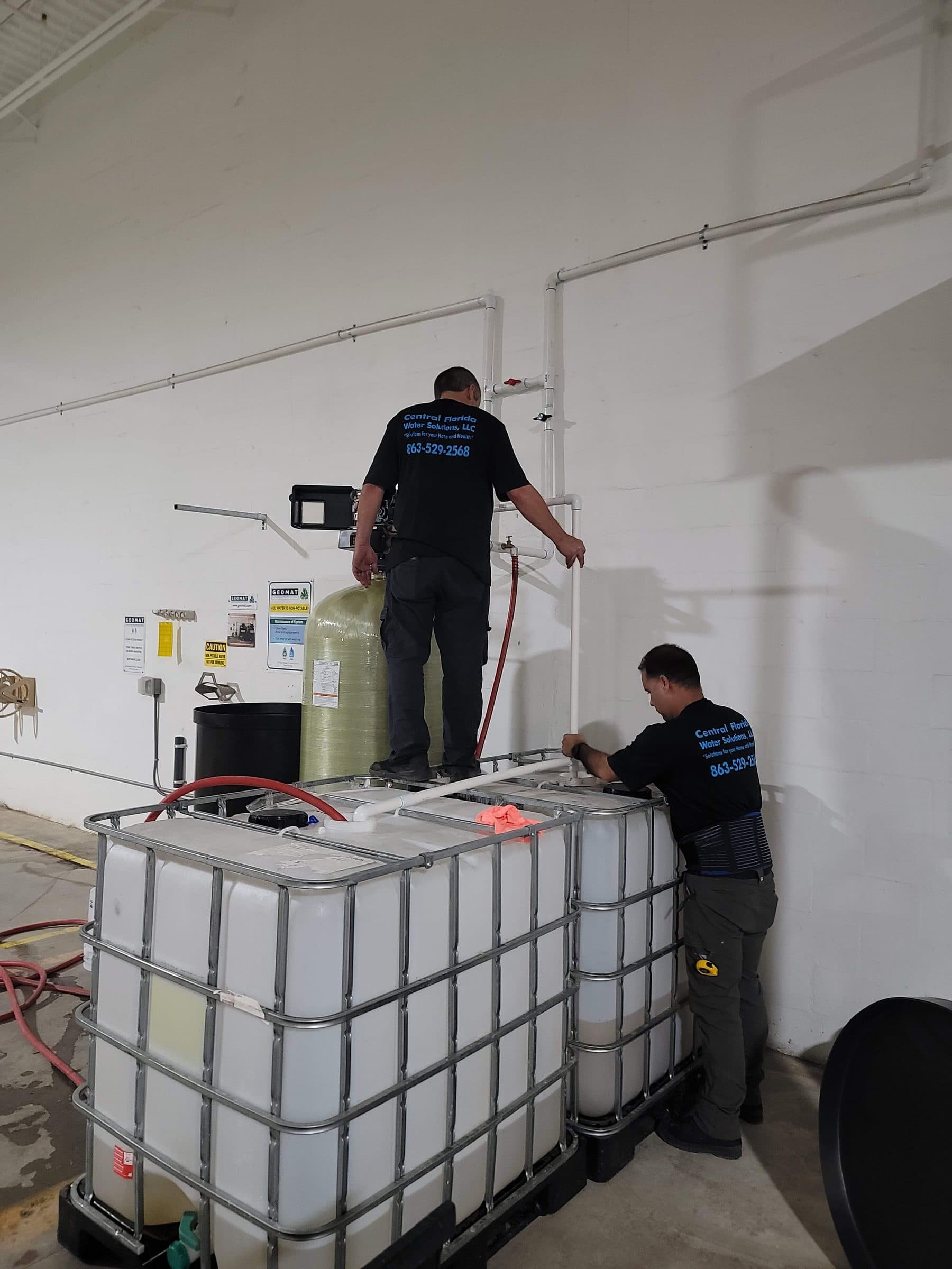 Central Florida Water Solutions team servicing bulk chemical totes at a commercial job